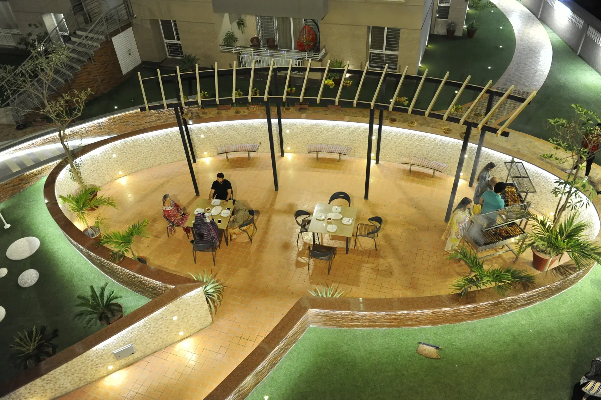Landscaped courtyard and podium promenade framed by reflecting water and shaded seating.