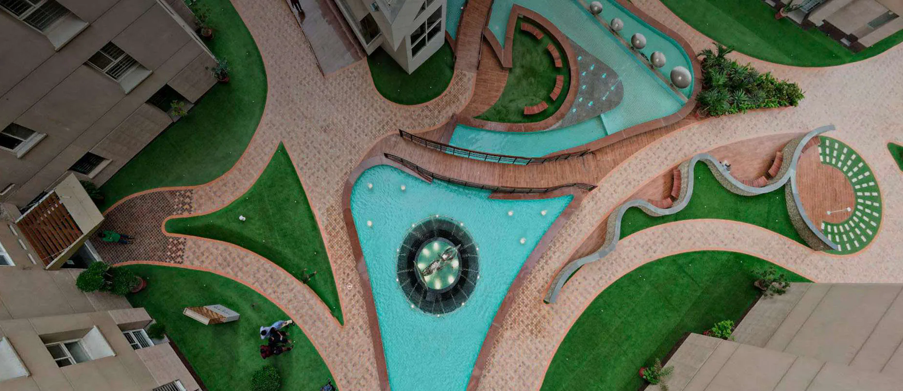 The landscaped court from above by day: lawns, paths and triangular pools